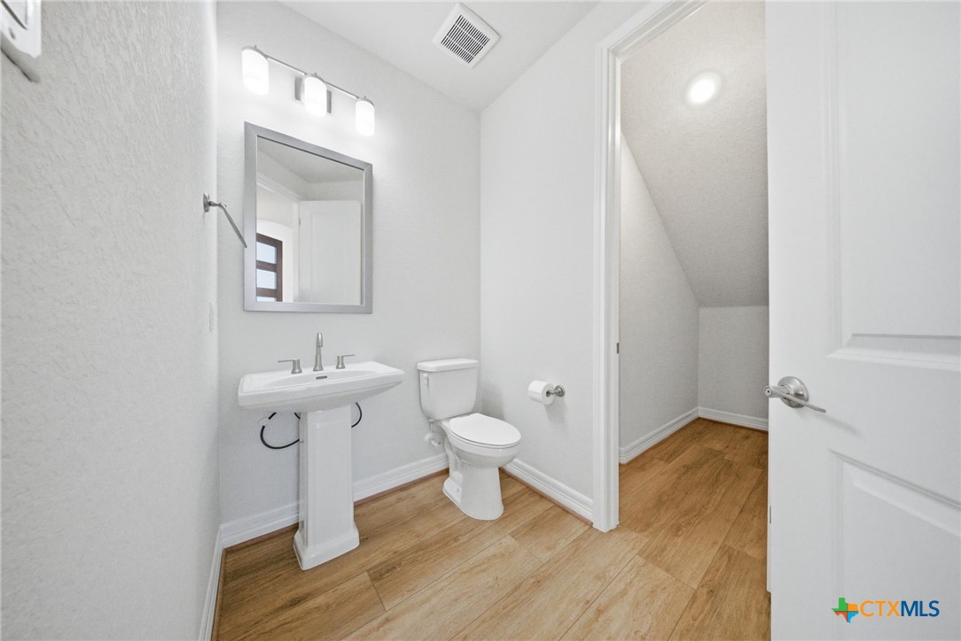 662 Hidden View Street New Braunfels, TX 78130 - Photo 9 of 46 a bathroom with a toilet sink and mirror