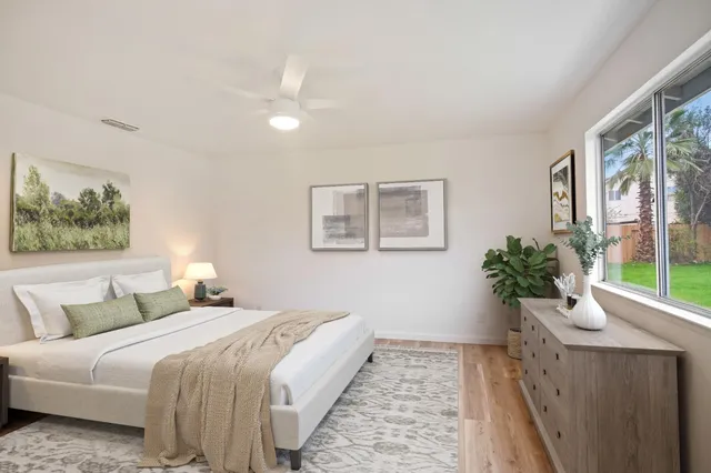 a bedroom with a large bed and a potted plant