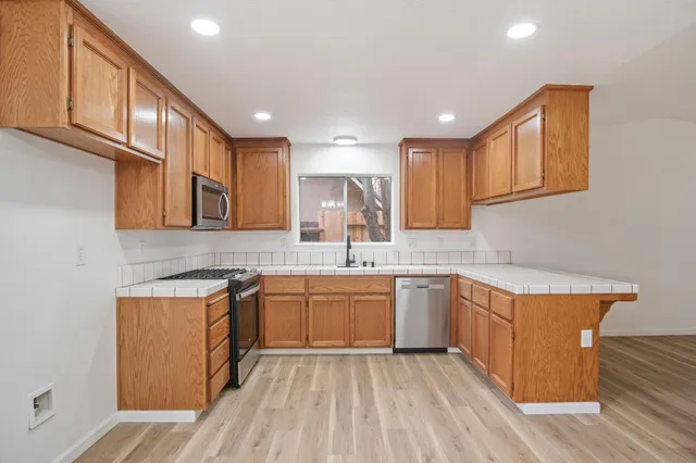 a kitchen with stainless steel appliances granite countertop a sink stove and cabinets