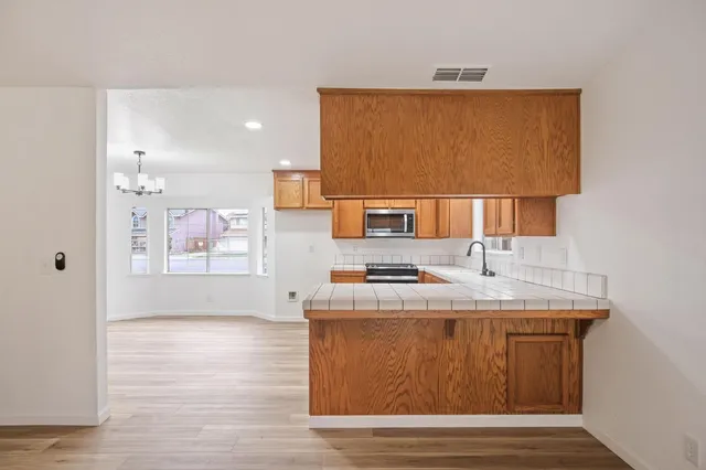 a kitchen with stainless steel appliances granite countertop a sink stove and wooden floor