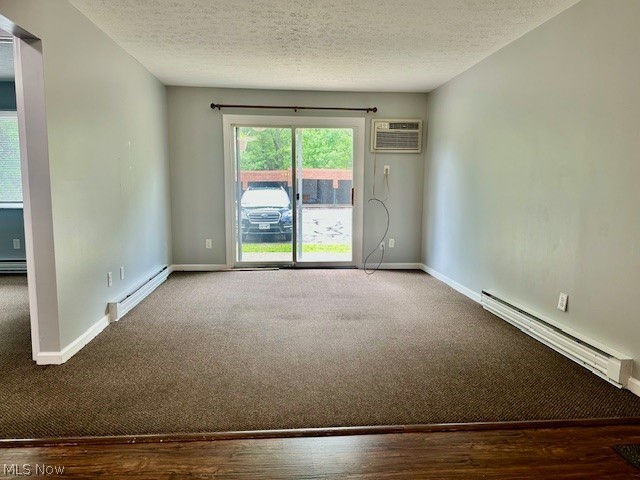 4376 Darrow Road, Unit 2 Stow, OH 44224 - Photo 6 of 26 Carpeted spare room with a baseboard heating unit, a wall mounted AC, a textured ceiling, and baseboards