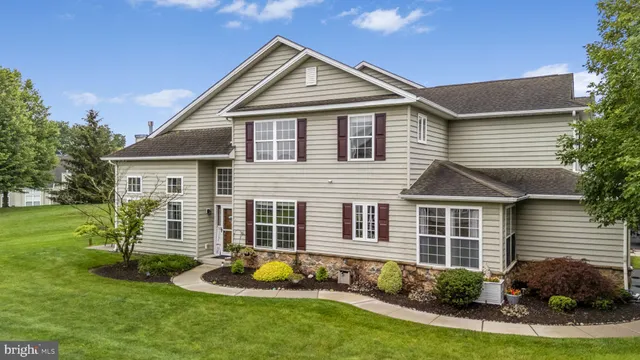 a front view of a house with a yard and potted plants
