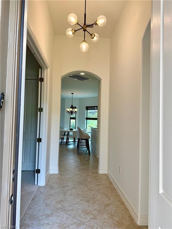 7476 Moorgate Point Way Naples, FL 34113 - Photo 2 of 20 an entryway and a livingroom with furniture chandelier