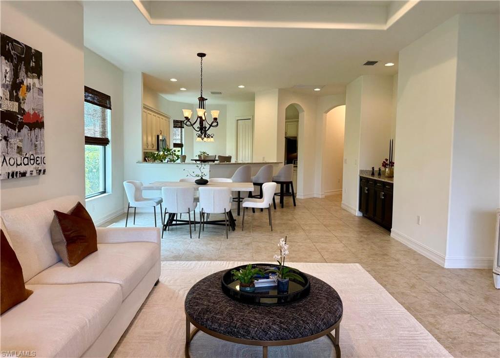 7476 Moorgate Point Way Naples, FL 34113 - Photo 5 of 20 a living room with furniture and a chandelier