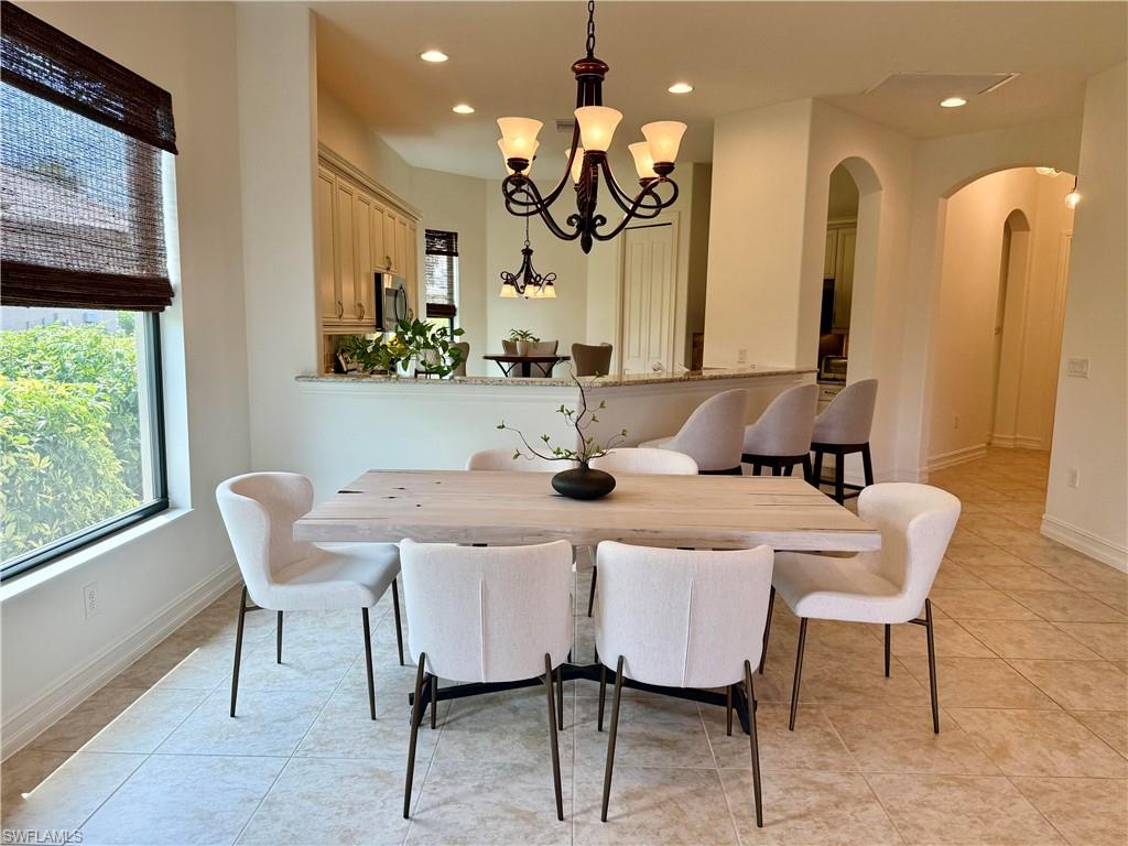7476 Moorgate Point Way Naples, FL 34113 - Photo 6 of 20 a view of a dining room with furniture and a large window