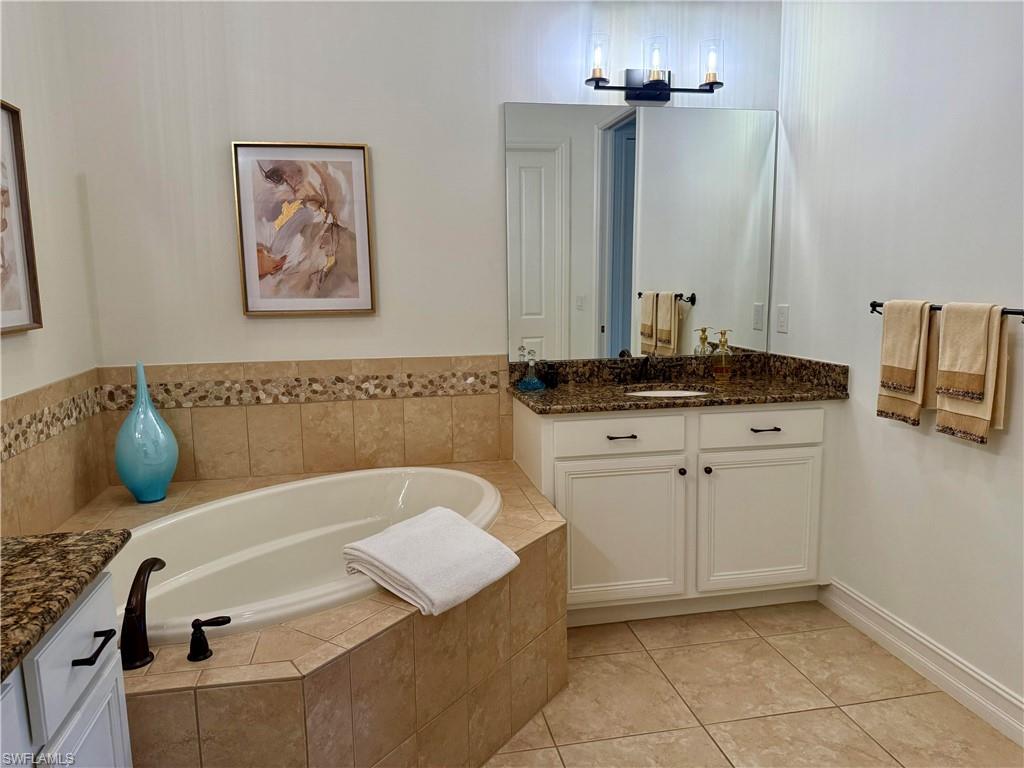 7476 Moorgate Point Way Naples, FL 34113 - Photo 9 of 20 a bathroom with a tub sink and mirror