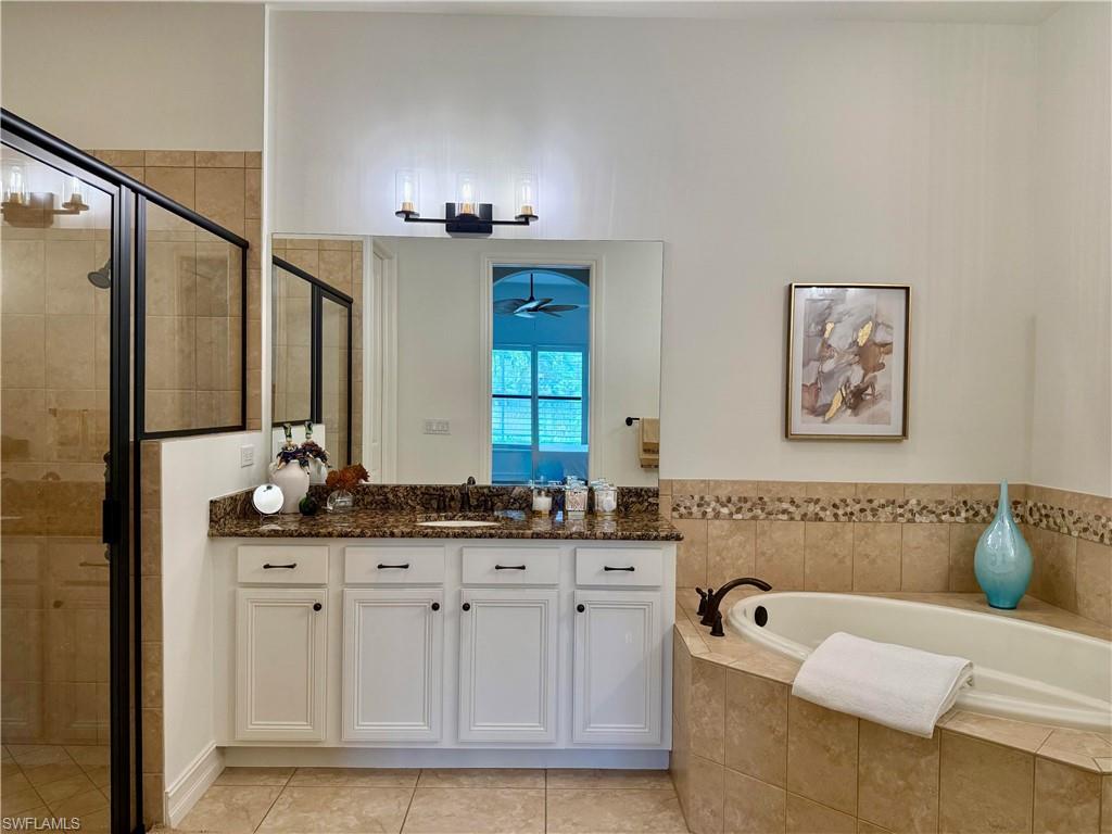 7476 Moorgate Point Way Naples, FL 34113 - Photo 10 of 20 a bathroom with a bathtub and a double vanity sink