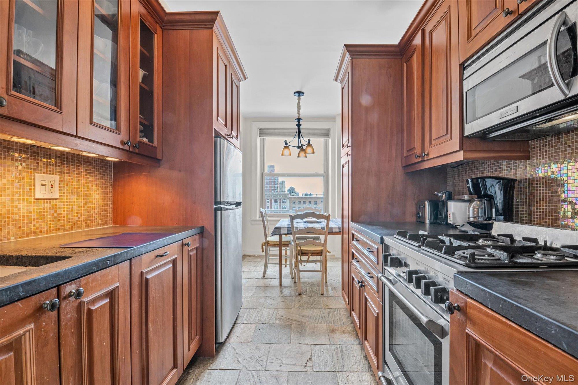 390 Riverside Drive, Unit 12AC Manhattan, NY 10025 - Photo 13 of 29 a kitchen with stainless steel appliances granite countertop a stove top oven a sink dishwasher and cabinets with wooden floor