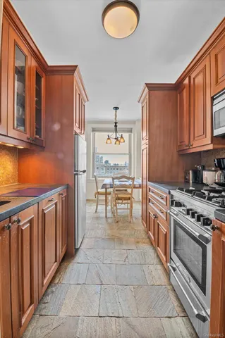 a kitchen with stainless steel appliances granite countertop a stove top oven a sink dishwasher and granite countertops with cabinets