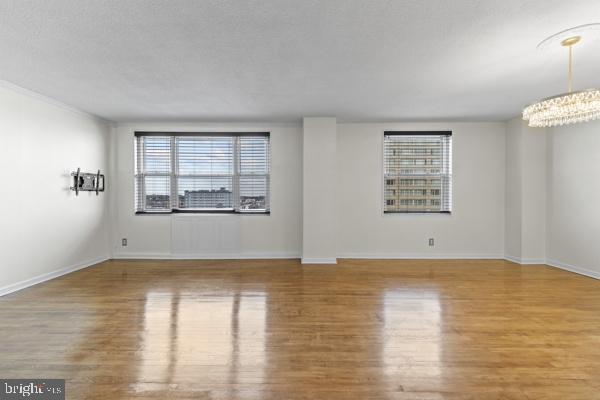 1101 St Paul Street, Unit 710 Baltimore, MD 21202 - Photo 12 of 21 an empty room with wooden floor cabinet and windows