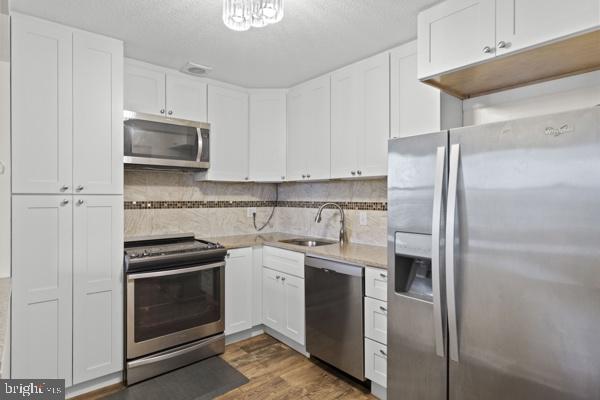 1101 St Paul Street, Unit 710 Baltimore, MD 21202 - Photo 7 of 21 a kitchen with stainless steel appliances granite countertop a refrigerator sink and stove