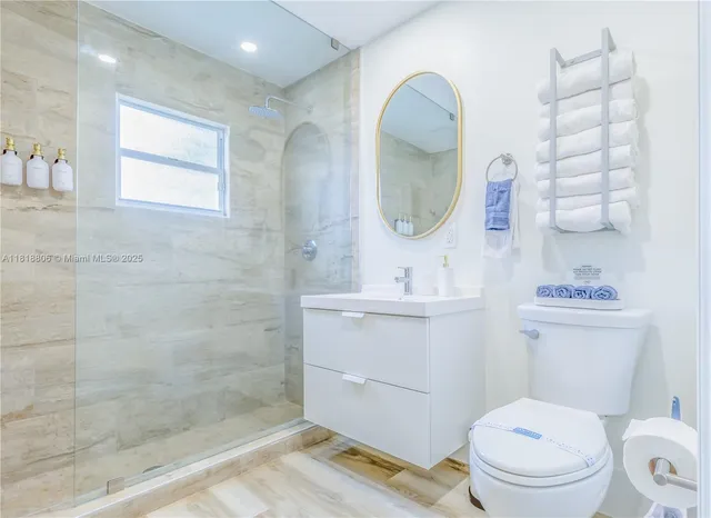 a bathroom with a toilet a sink and mirror