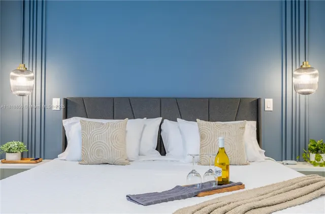 a bedroom with a bed and a lamp on dresser