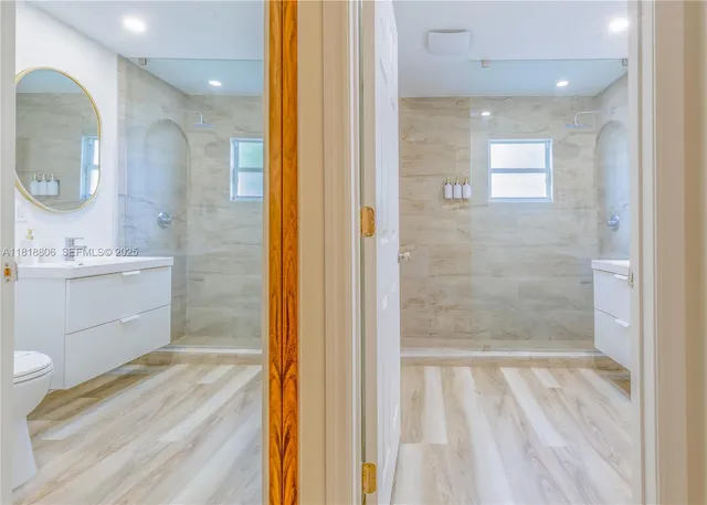 a bathroom with a sink a mirror a vanity and shower