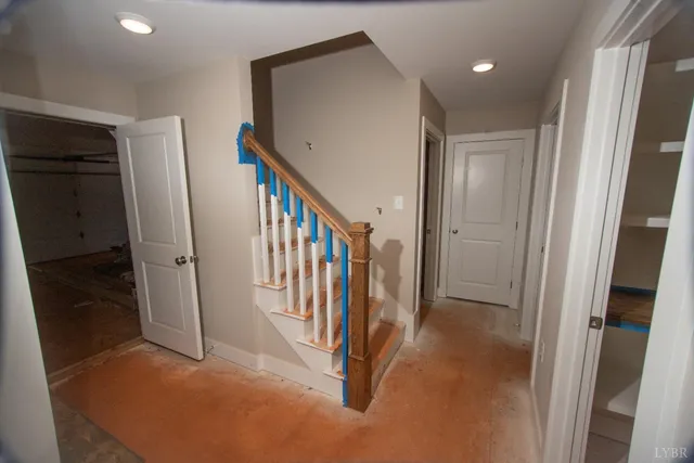 a view of a hallway with staircase and floor to ceiling window