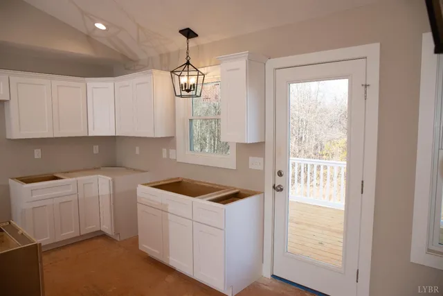 a kitchen filled with white cabinets and white appliances