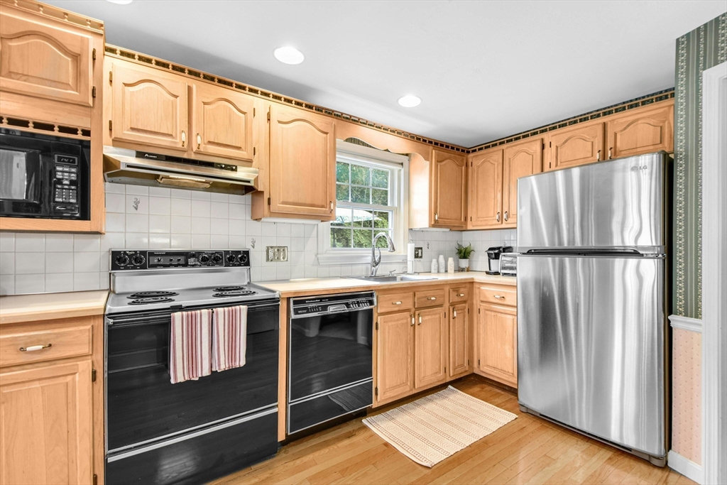 36 Turner Street Norfolk, MA 02056 - Photo 5 of 41 a kitchen with stainless steel appliances granite countertop a refrigerator a sink dishwasher a stove and white countertops with wooden floor