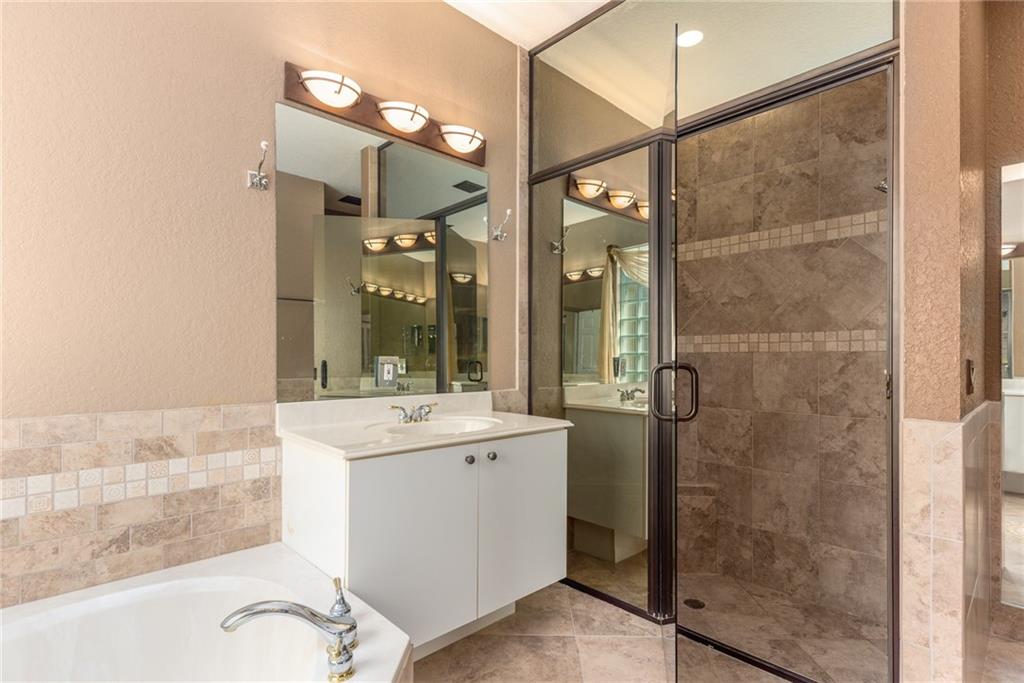 2103 Northwest Marsh Rabbit Lane Stuart, FL 34994 - Photo 13 of 20 a bathroom with a sink and mirror with shower