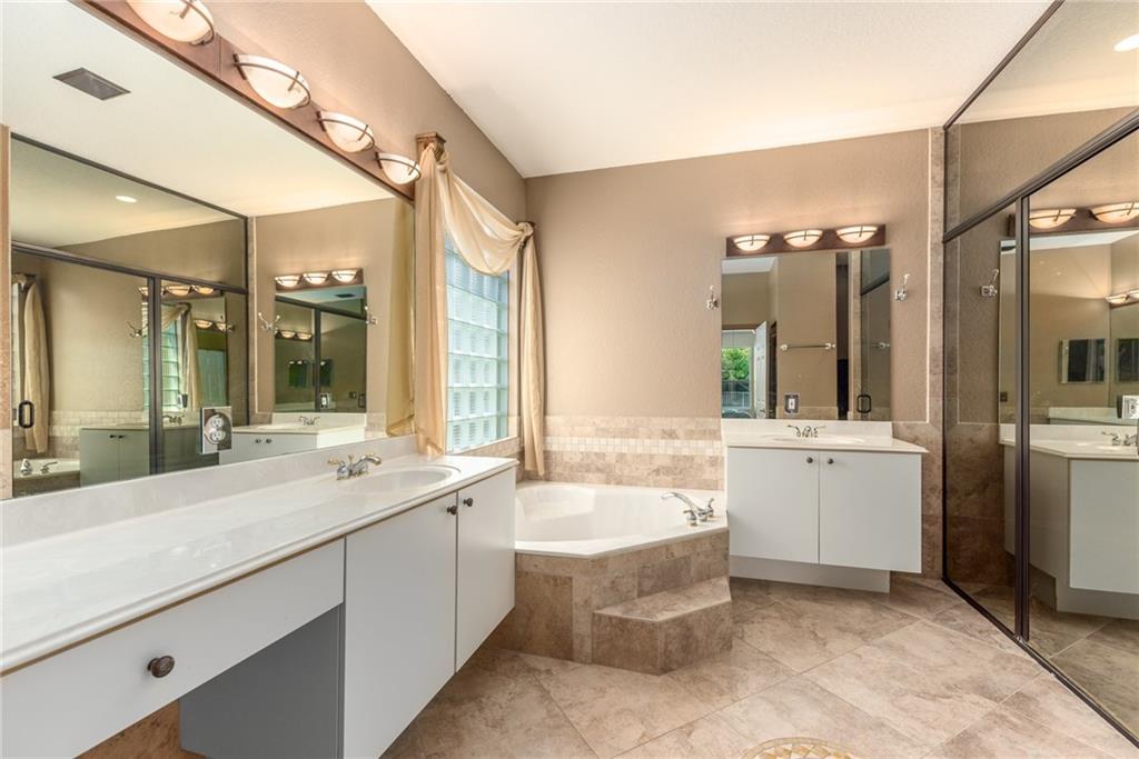 2103 Northwest Marsh Rabbit Lane Stuart, FL 34994 - Photo 14 of 20 a bathroom with a tub sink shower and mirror