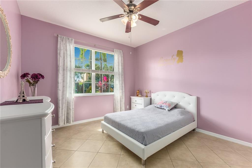 2103 Northwest Marsh Rabbit Lane Stuart, FL 34994 - Photo 15 of 20 a bedroom with a bed and a chandelier
