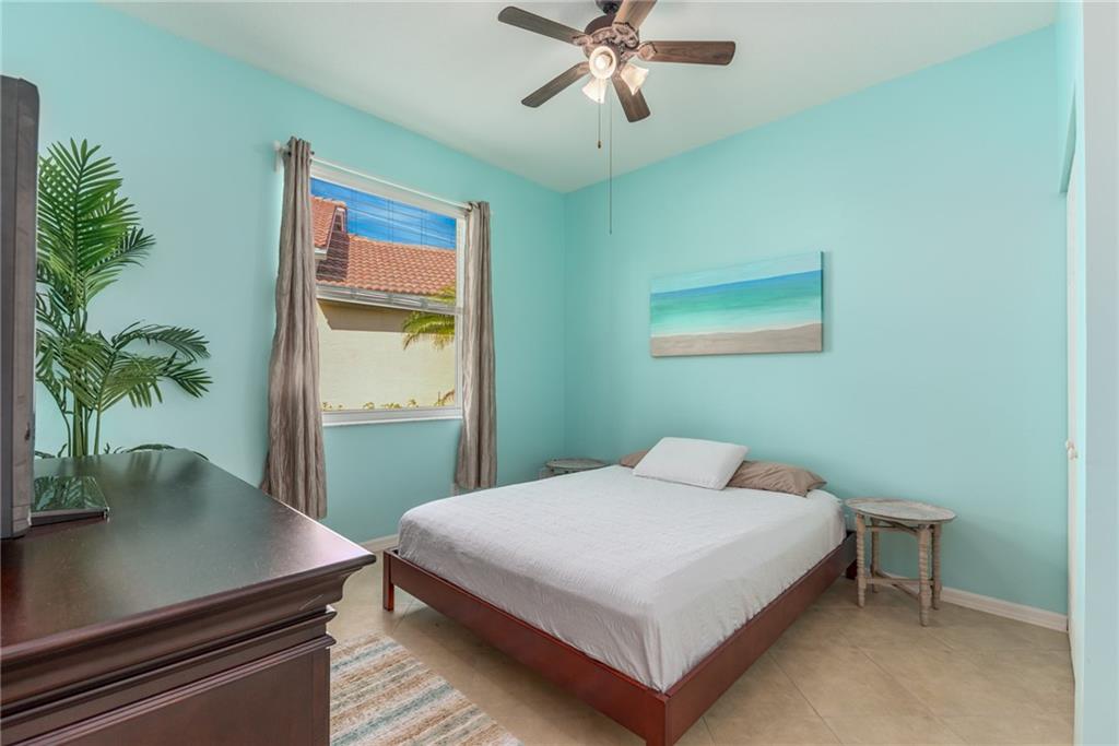 2103 Northwest Marsh Rabbit Lane Stuart, FL 34994 - Photo 16 of 20 a bedroom with a bed table and a window