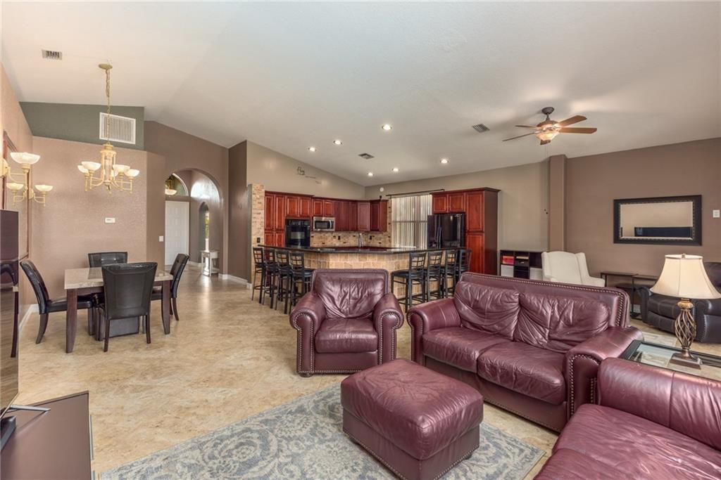 2103 Northwest Marsh Rabbit Lane Stuart, FL 34994 - Photo 7 of 20 a living room with furniture kitchen view and a chandelier