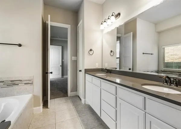 a spacious bathroom with a granite countertop sink a toilet a mirror and bathtub