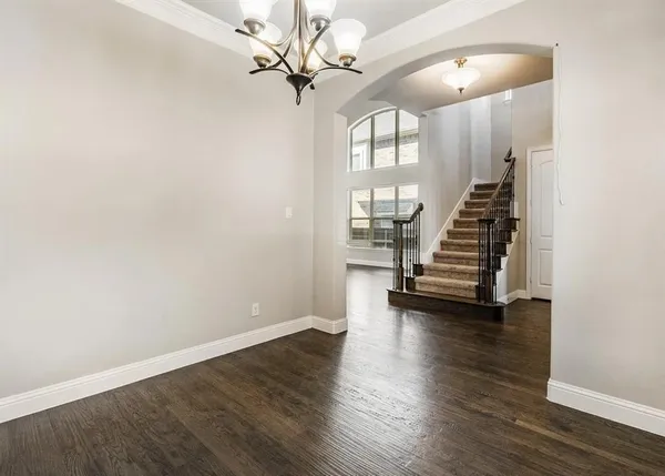 an empty room with wooden floor and staircase