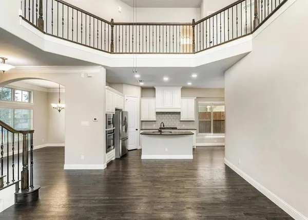 a hallway with wooden floor and a kitchen