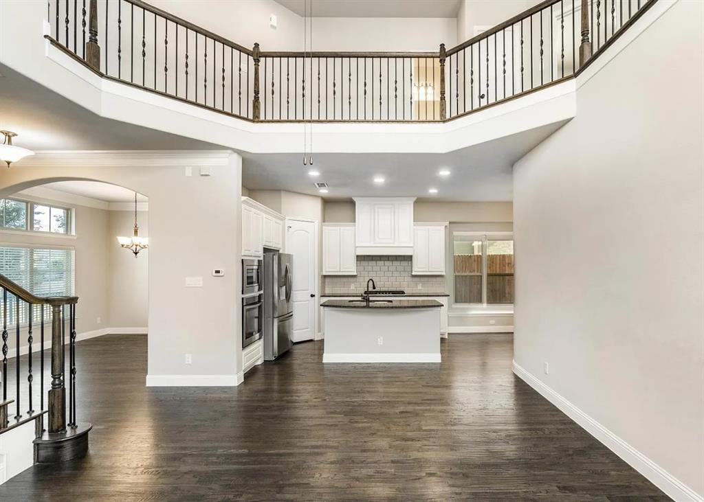 5215 Wakefield Drive Irving, TX 75038 - Photo 8 of 36 a hallway with wooden floor and a kitchen