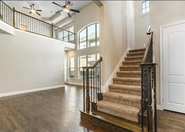 a view of staircase with lots of frames and white walls