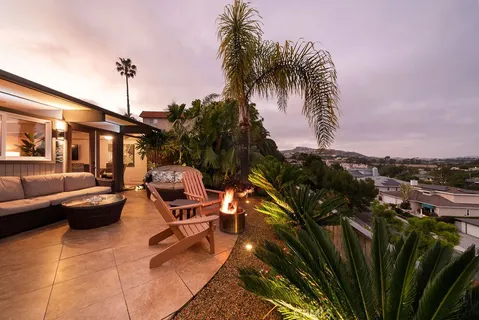 a living room with granite countertop couches a fireplace and kitchen view with wooden floor