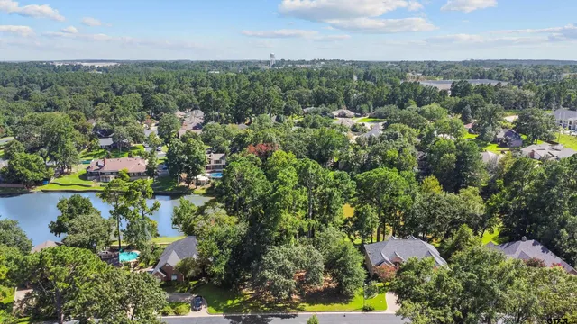 an aerial view of residential house with outdoor space and trees all around