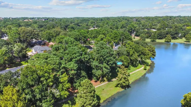 an aerial view of a houses with a yard and lake view