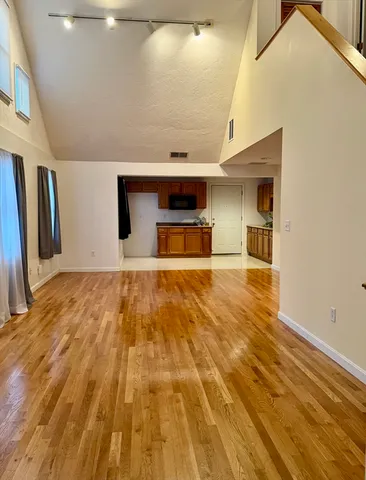 a view of empty room with wooden floor