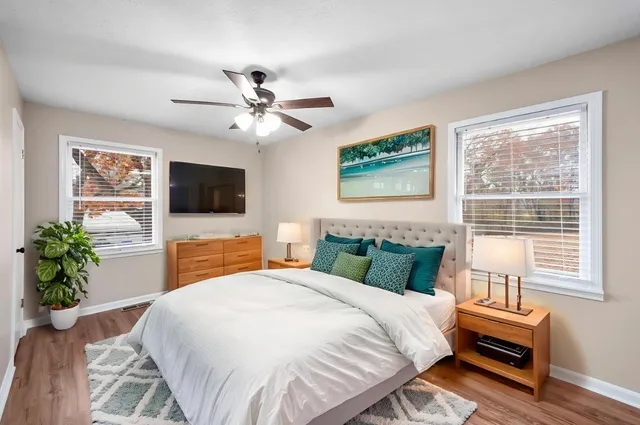 a view of empty room with wooden floor and fan