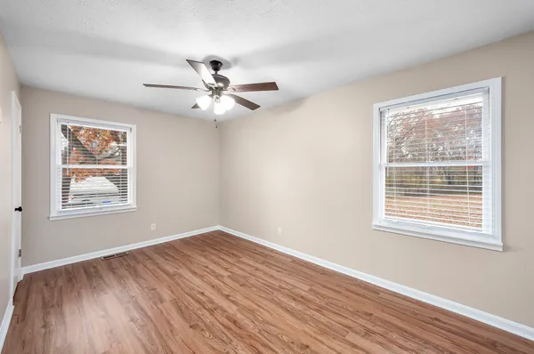 a view of an empty room with wooden floor