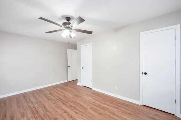 a bedroom with a bed and a flat screen tv with wooden floor
