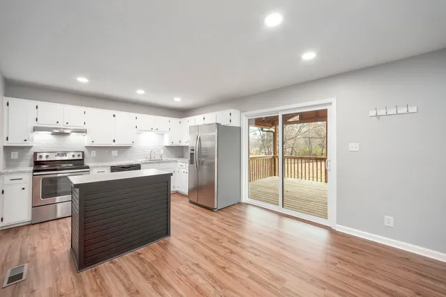 a kitchen with stainless steel appliances granite countertop a refrigerator and a stove top oven
