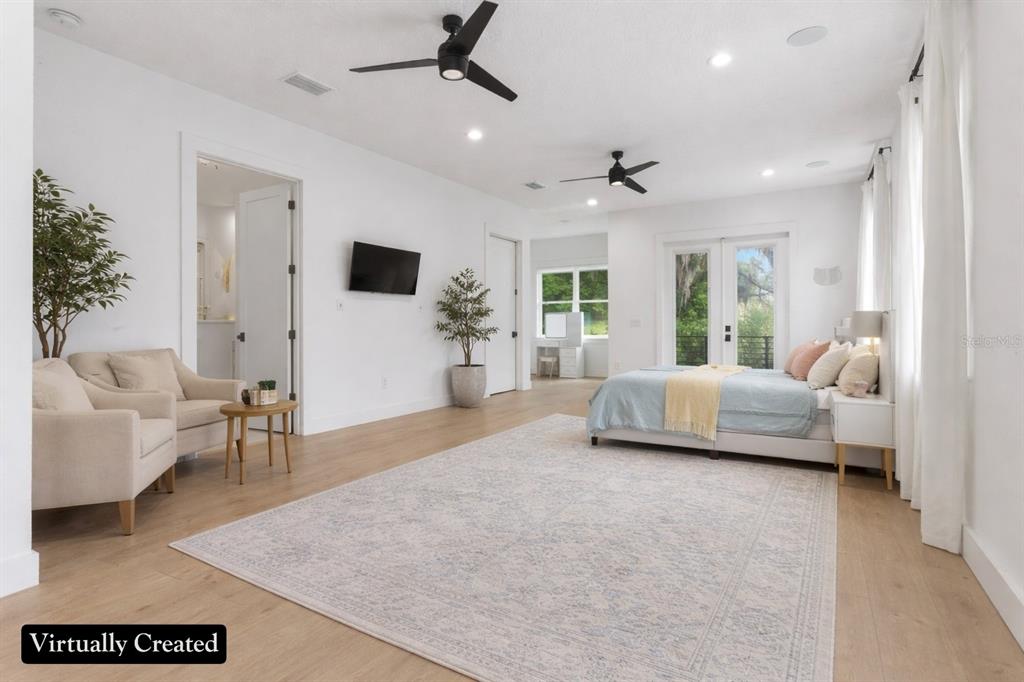 8241 Cass Road Zephyrhills, FL 33540 - Photo 65 of 97 a spacious bedroom with a bed a couch and a large window