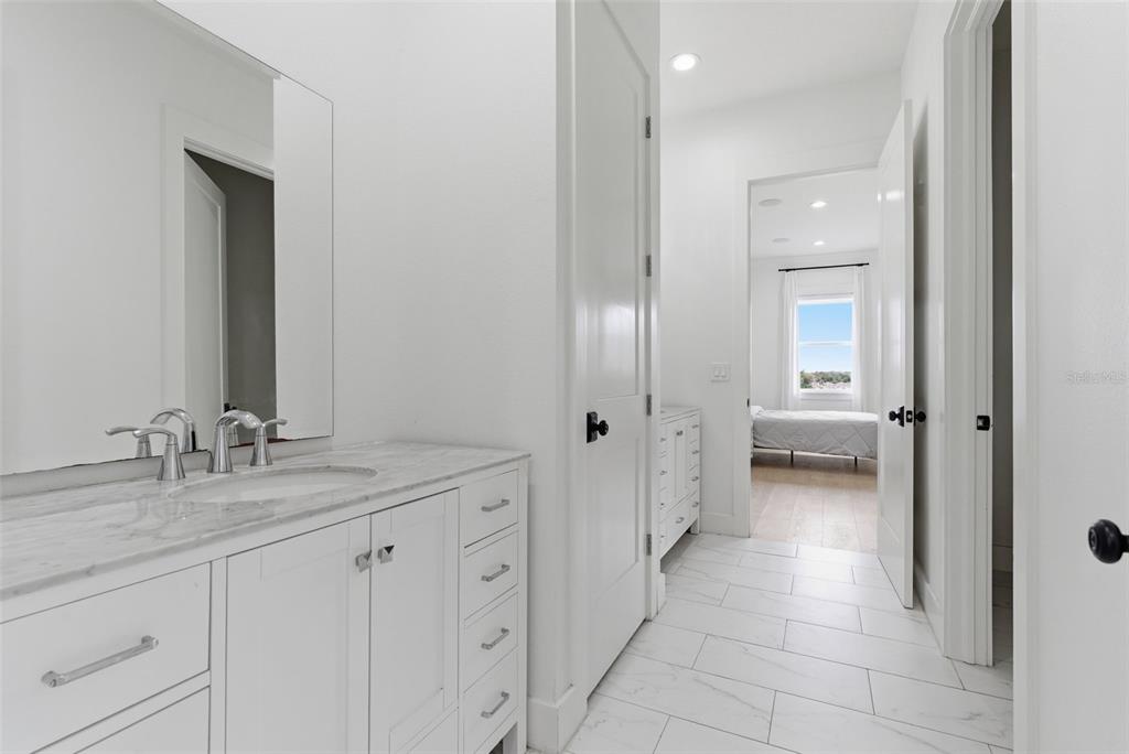8241 Cass Road Zephyrhills, FL 33540 - Photo 70 of 97 a en suite bathroom with a granite countertop sink and a mirror