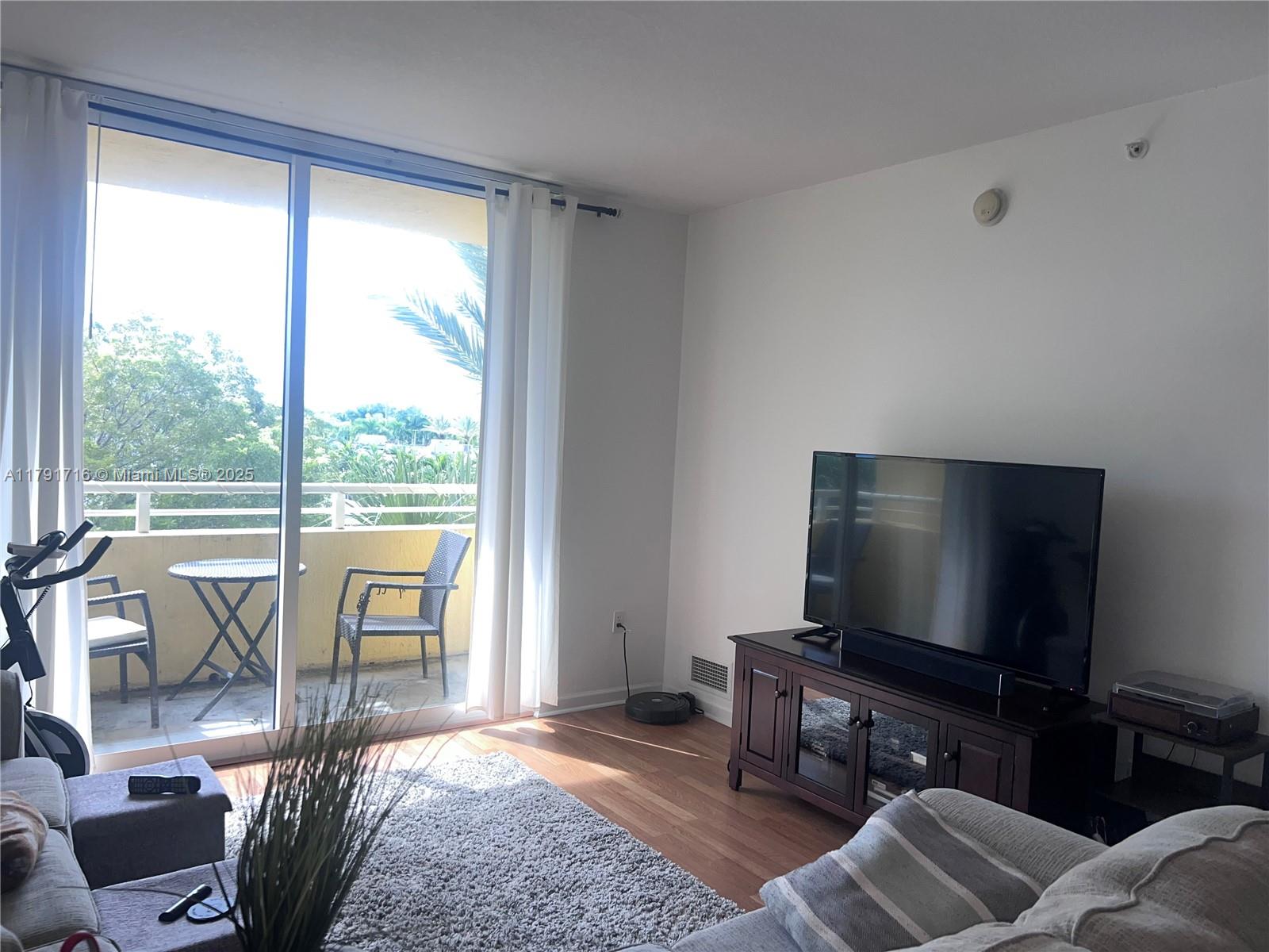2775 Northeast 187th Street, Unit 311 Aventura, FL 33180 - Photo 2 of 28 a living room with furniture and a flat screen tv