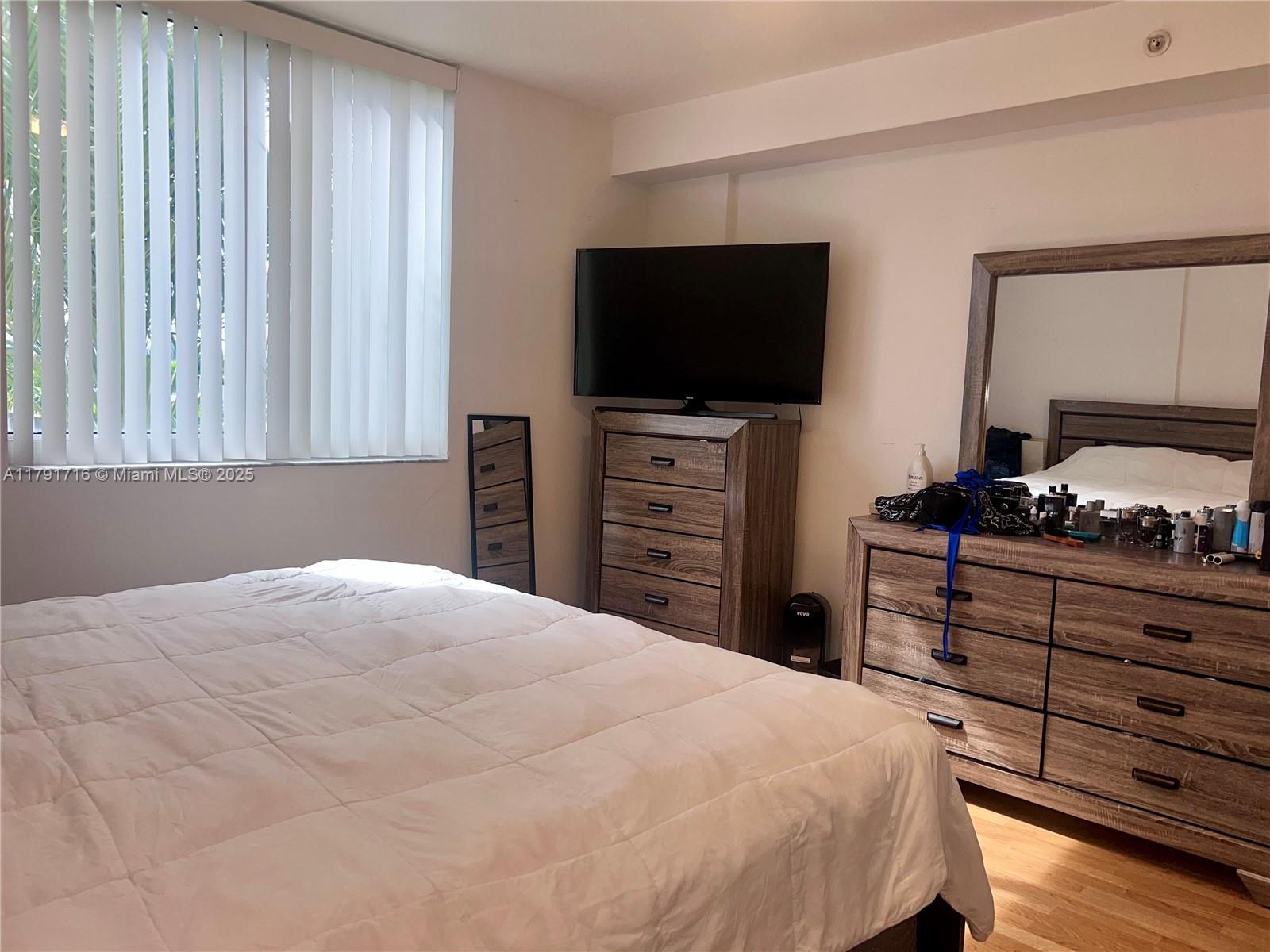 2775 Northeast 187th Street, Unit 311 Aventura, FL 33180 - Photo 5 of 28 a bedroom with a bed and a flat screen tv