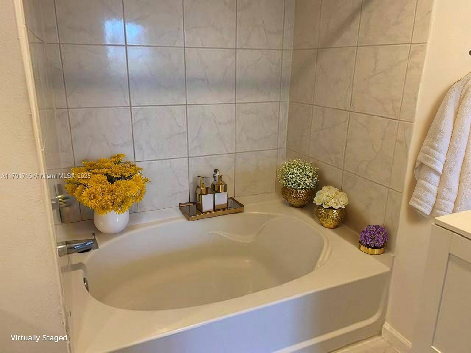 2775 Northeast 187th Street, Unit 311 Aventura, FL 33180 - Photo 7 of 28 a bathroom with a tub