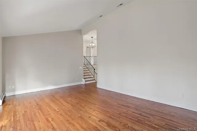 a view of staircase with lots of frames on wall and wooden floor