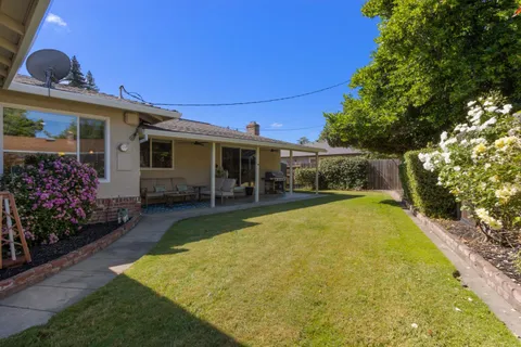a view of a house with swimming pool and a yard