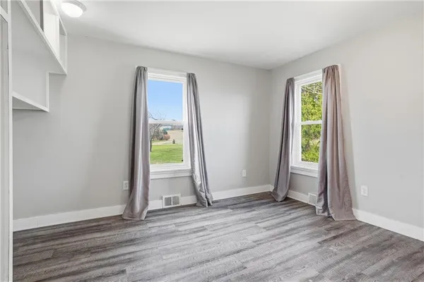 an empty room with a window and a chandelier