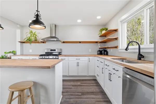 a kitchen with a sink a counter top space stainless steel appliances and cabinets