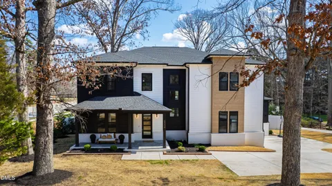 a front view of a building with street view and trees