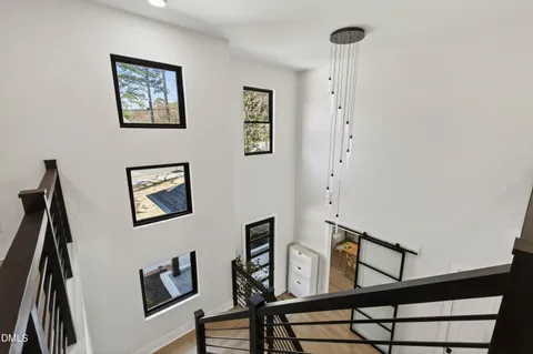 a view of a hallway with wooden floor and windows